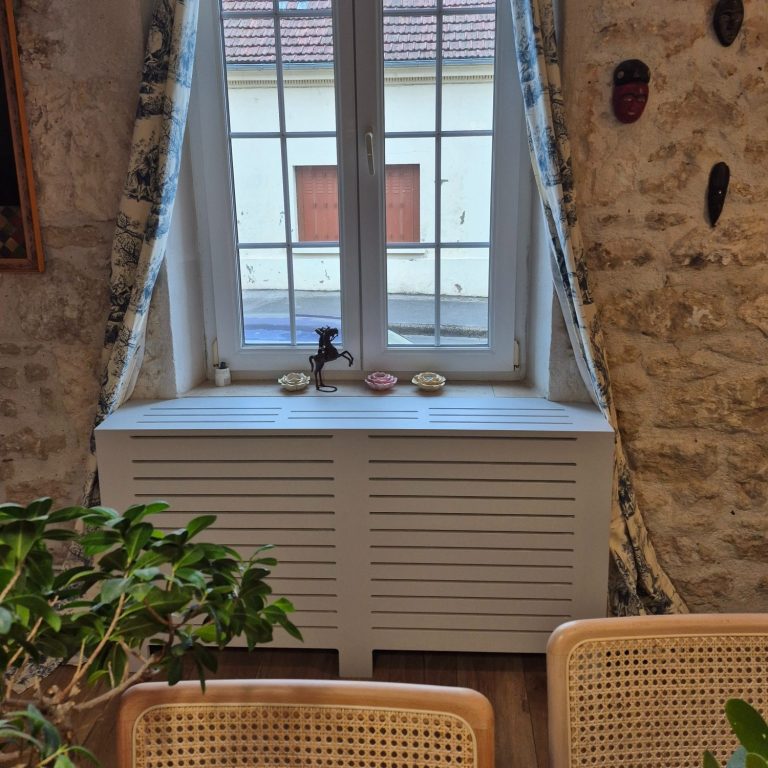 Cache-radiateur en MDF ajouré laqué gris clair.